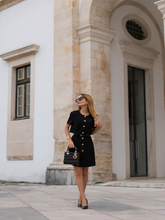 A woman wears a black dress
